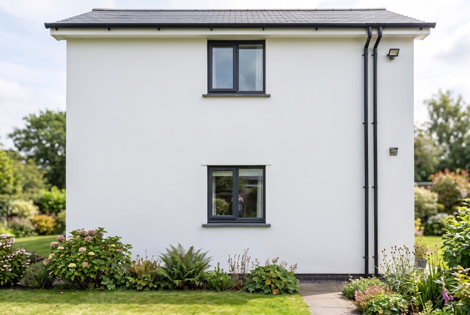 The same Devon elevation after softwash render cleaning, the white render even and free of algae